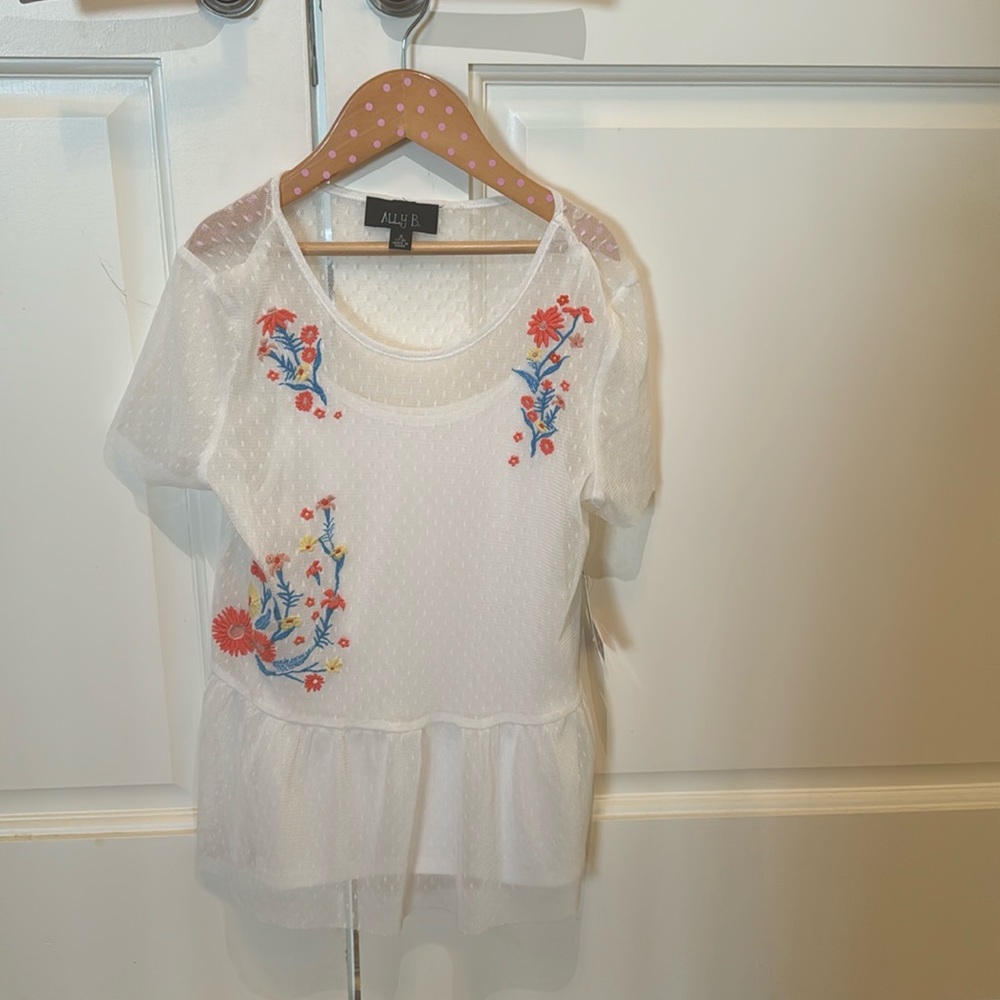 White blouse embroidered with flowers.